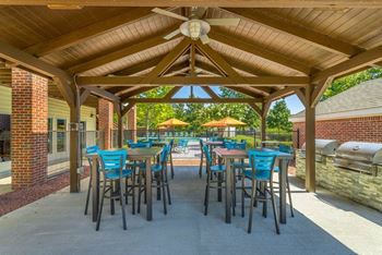 a patio with tables and chairs and umbrellas